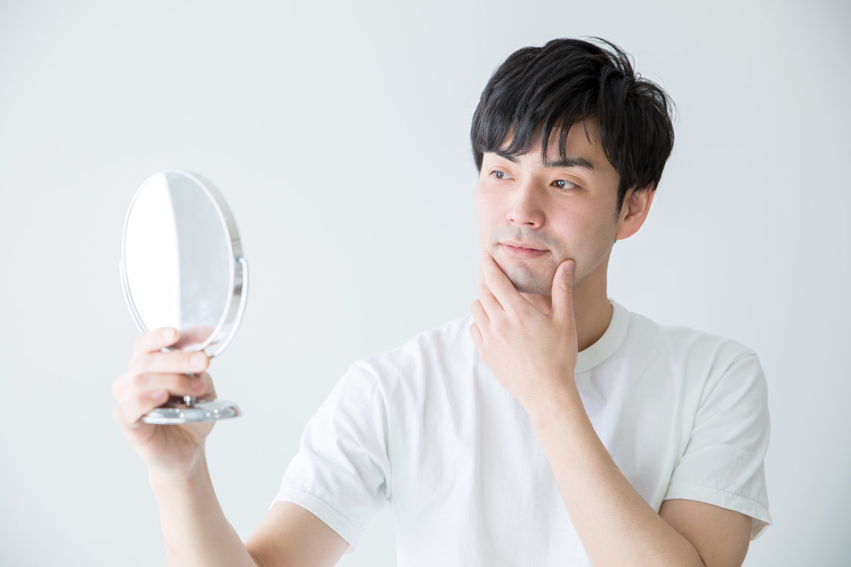 写真：鏡を見る男性
